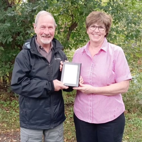 Alvin Lake recieves his Rural Frontenac Community Services life membership from Anne Howes.